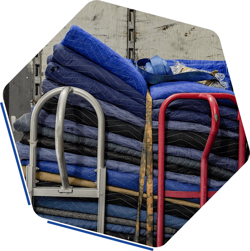 Blue moving blankets stacked on carts for relocation services.