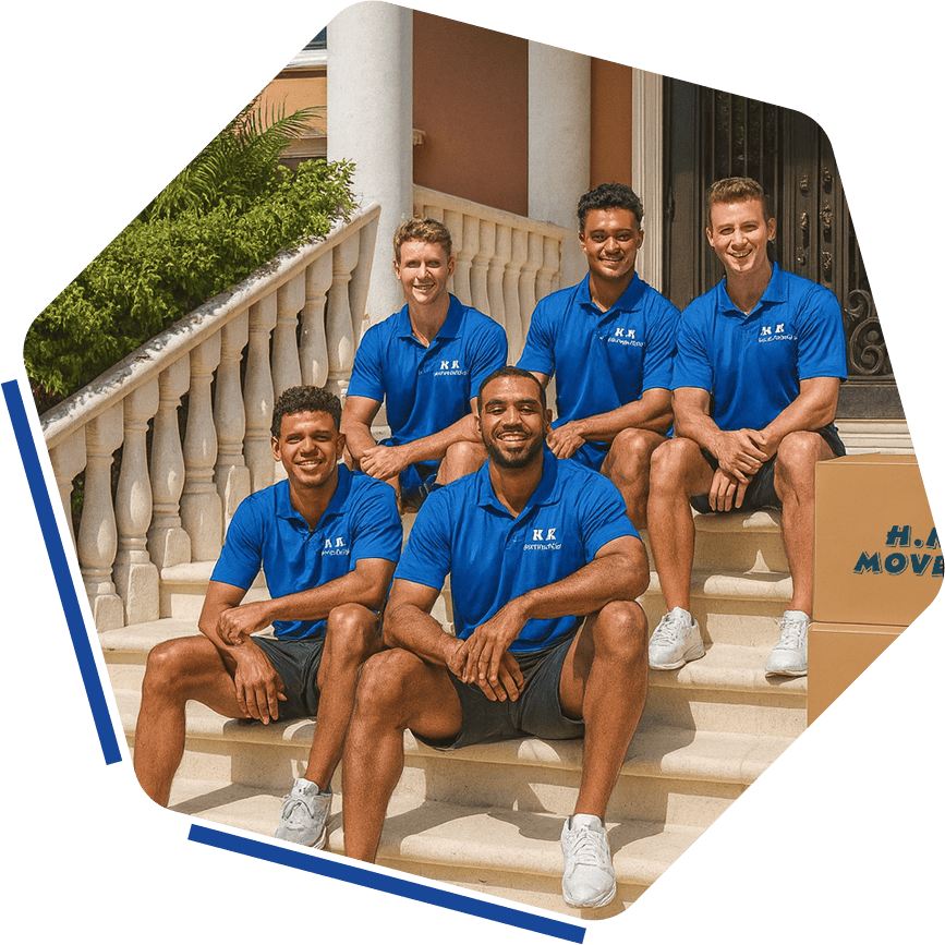 Professional moving team in blue uniforms, happy and ready to assist with residential and commercial moves, at the front steps of a beautiful home.