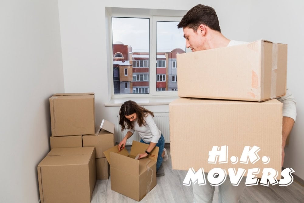 Efficient moving service with professional movers packing and transporting boxes in a modern apartment, ensuring stress-free relocation.