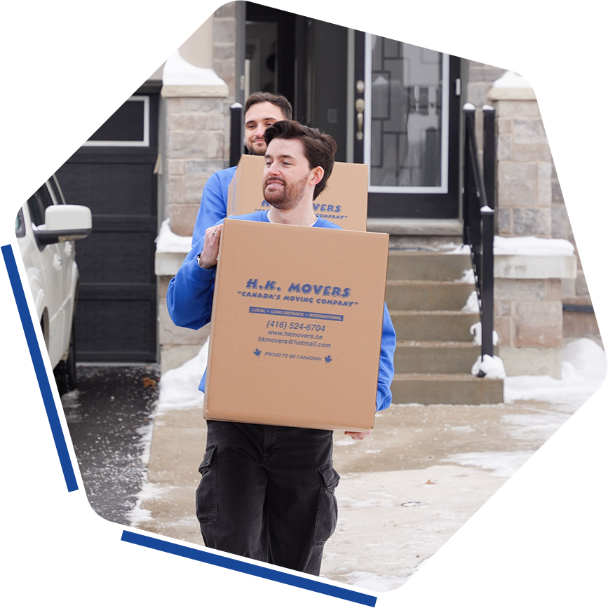 Movers carrying boxes outside a house