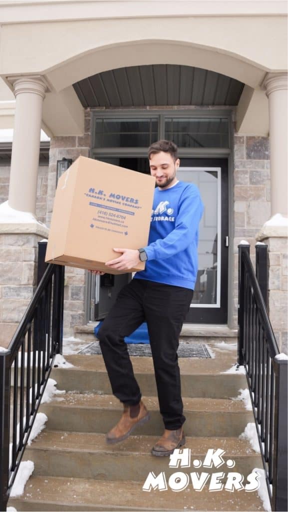 Mover carrying box down stairs in winter.