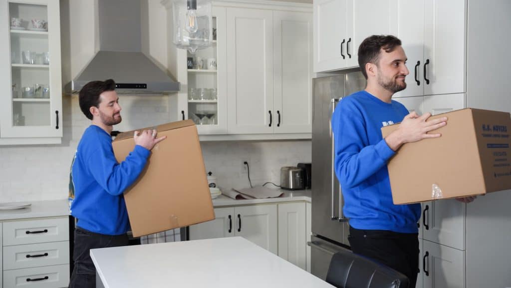 Moving professionals packing boxes in a modern kitchen for a smooth relocation.