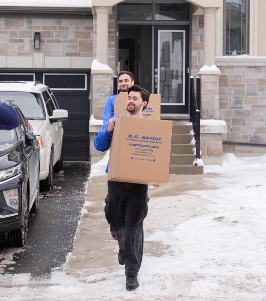 Two professional movers carrying boxes outside a Vaughan condo building, demonstrating efficient and careful moving services for condo residents.